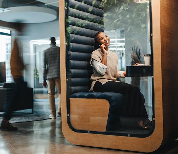 lady in sound proof booth on phone in office