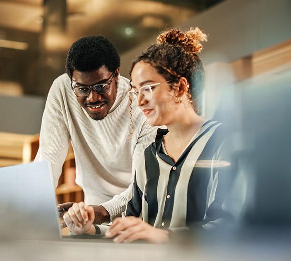 Business people looking at screen on desk